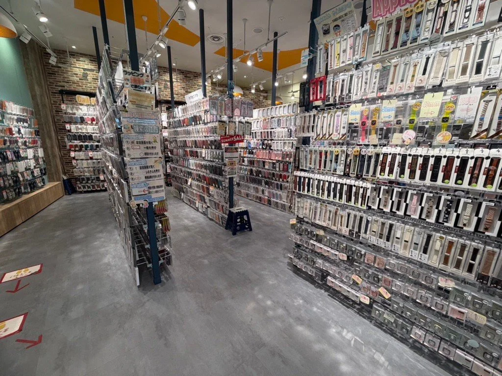 スマートフォンアクセサリーが並ぶ明るい店内の通路