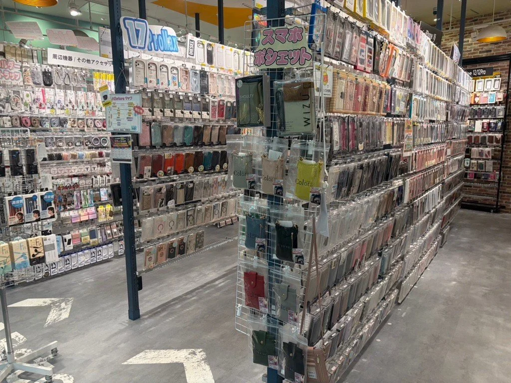 スマートフォンケースと充電用品が整然と並ぶ店内の商品陳列棚